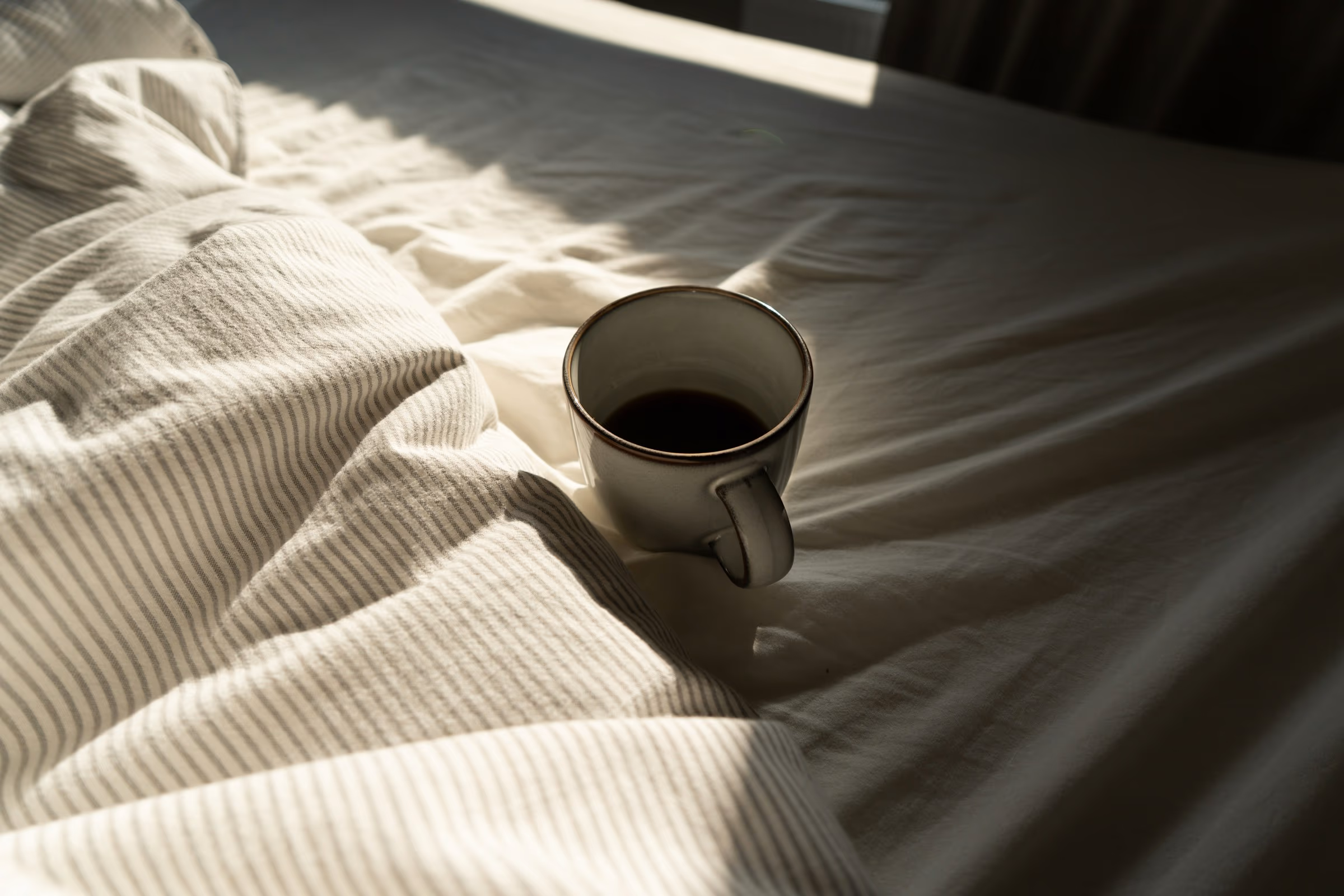 Tasse de café fumante posée sur une table au petit matin