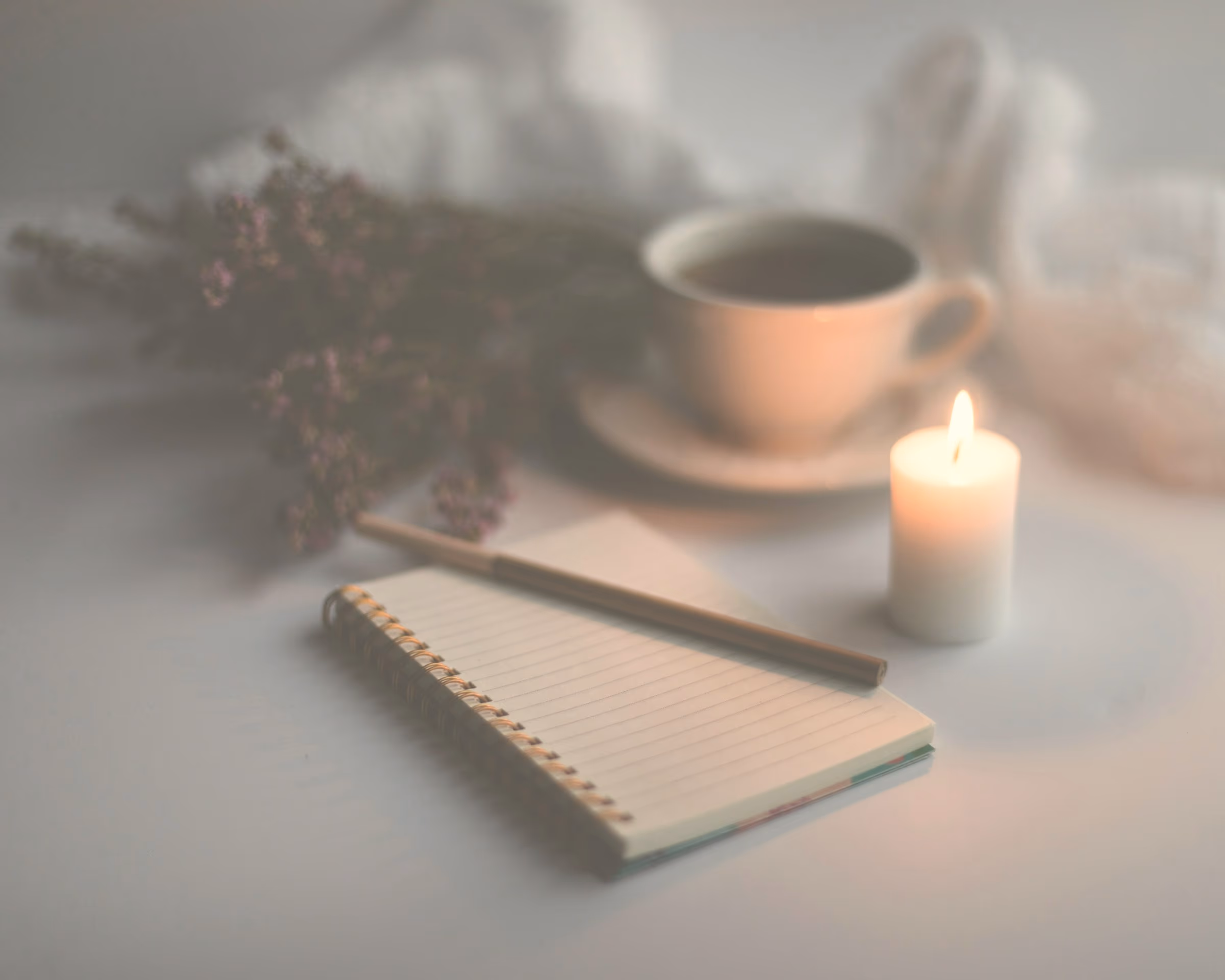 Carnet ouvert et stylo posés sous la lumière chaude d'une lampe, dans le calme d'une fin de soirée