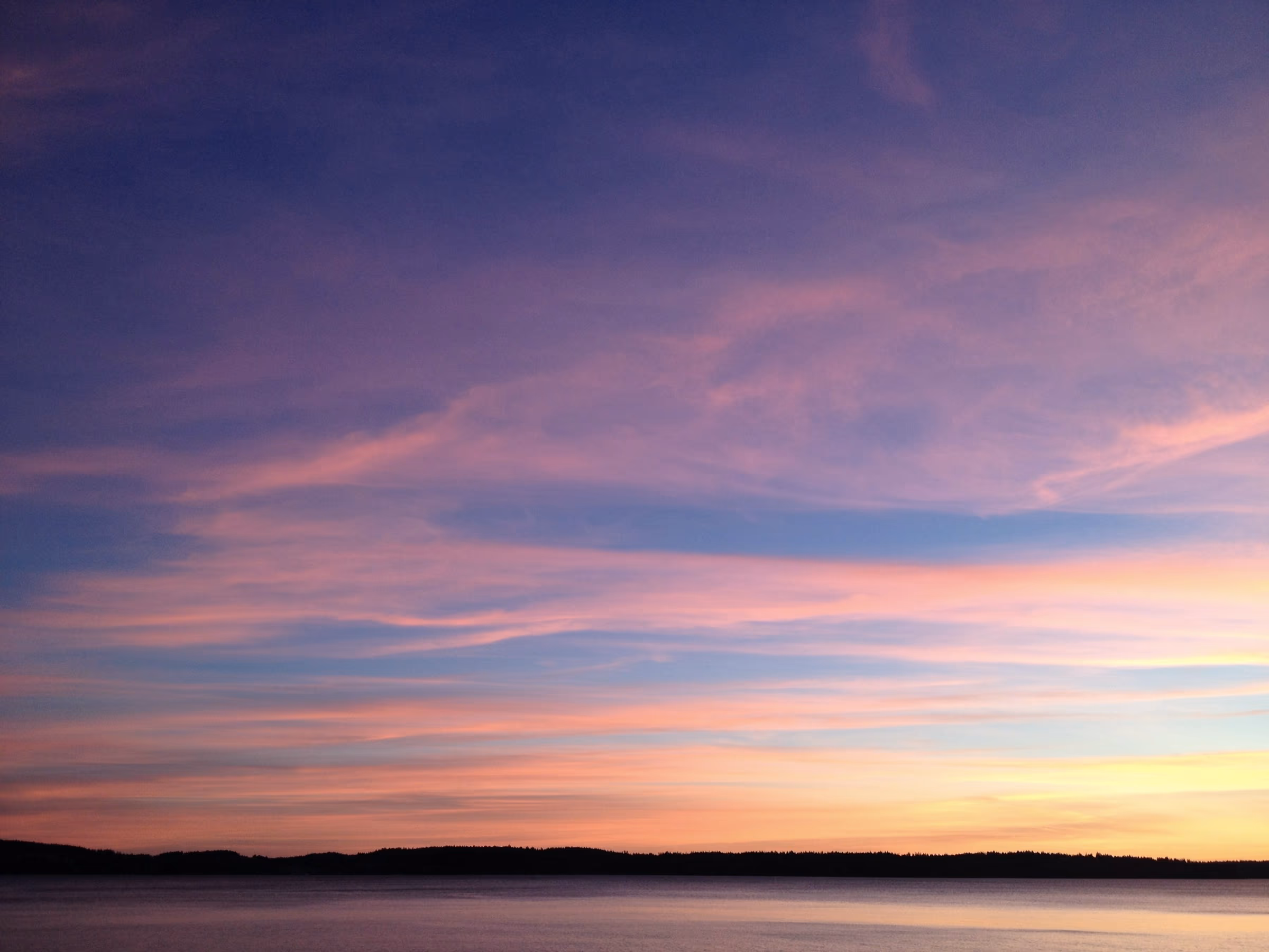 Ciel de crépuscule aux teintes orangées et bleutées au-dessus d'une ligne d'horizon
