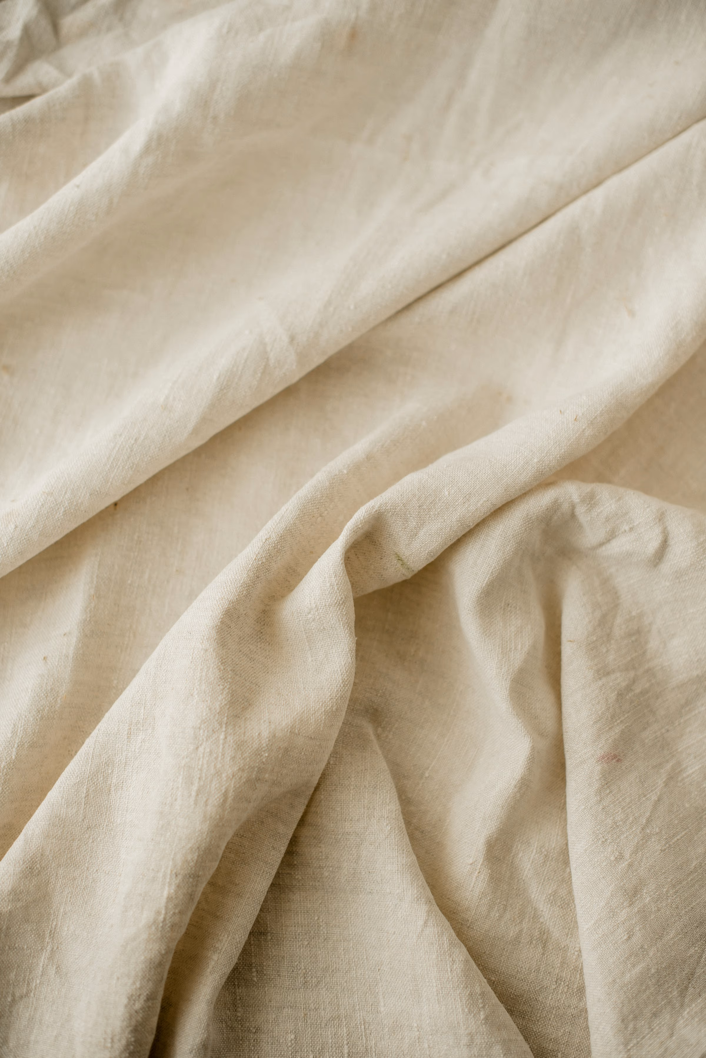Gros plan sur un tissu de coton écru froissé aux plis souples