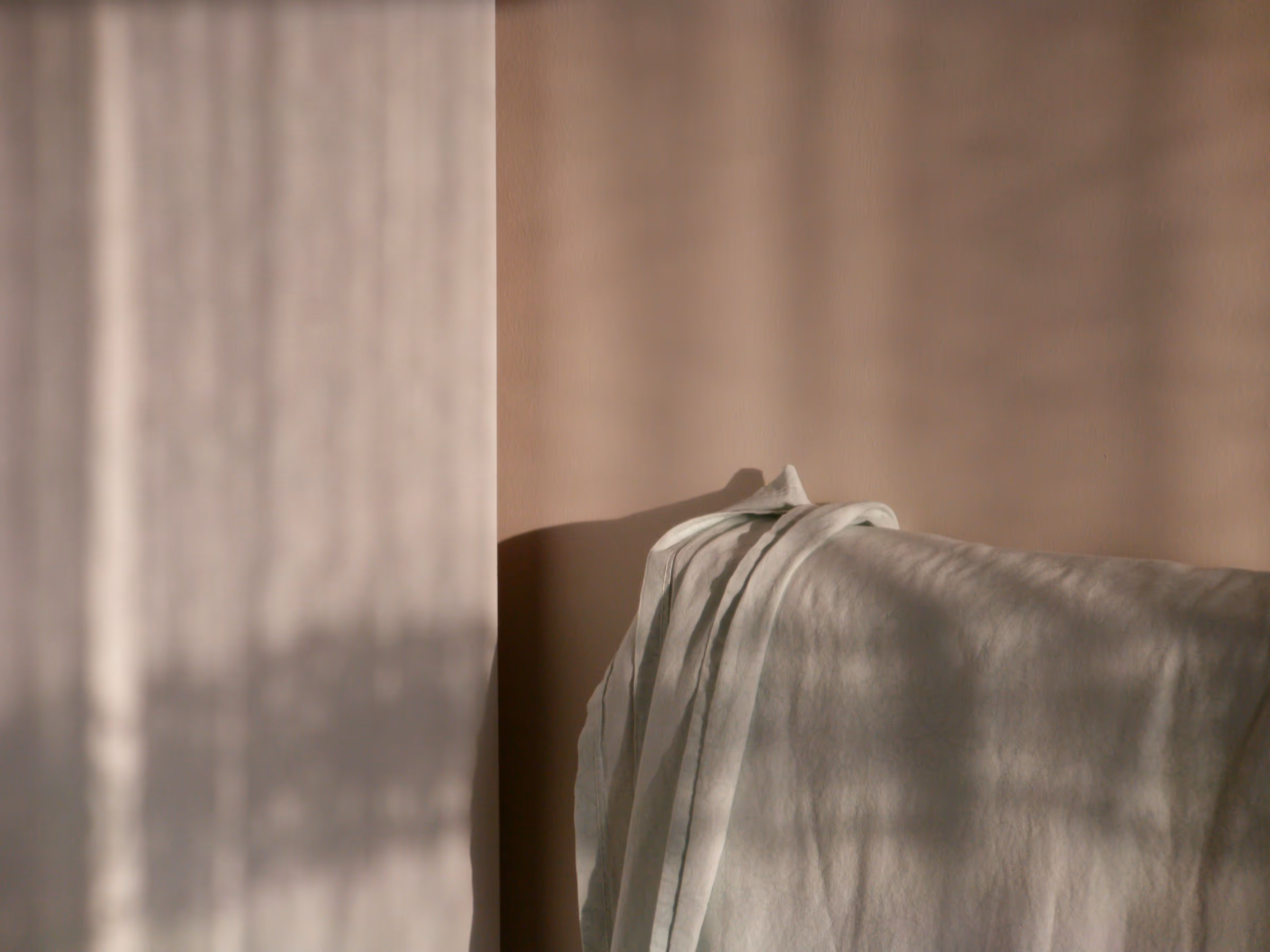 Linge de lit en tissu naturel froissé baigné d'une lumière douce
